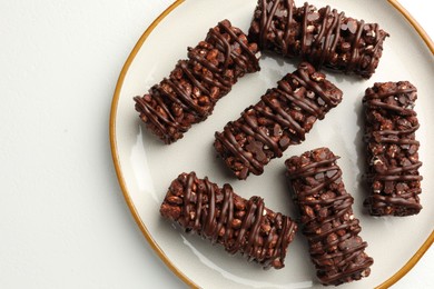 Delicious chocolate puffed rice bars on white table, top view. Space for text