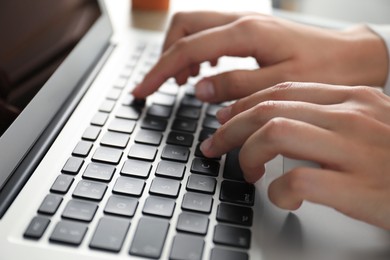 Photo of Businesswoman using laptop indoors, closeup. Modern technology