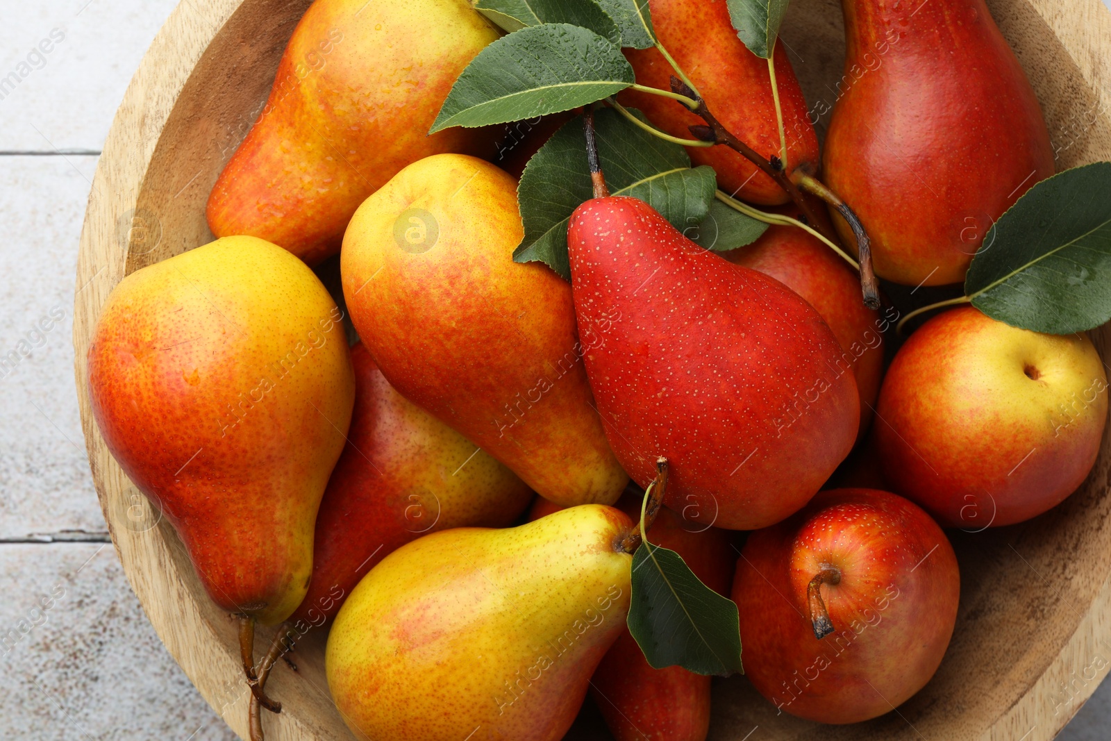 Photo of Ripe juicy pears on light tiled table, top view