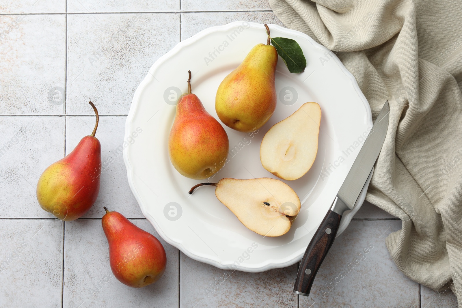 Photo of Ripe juicy pears on light tiled table, flat lay