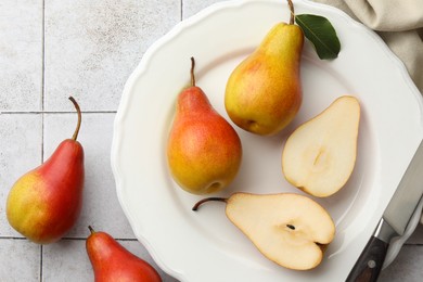 Photo of Ripe juicy pears on light tiled table, flat lay