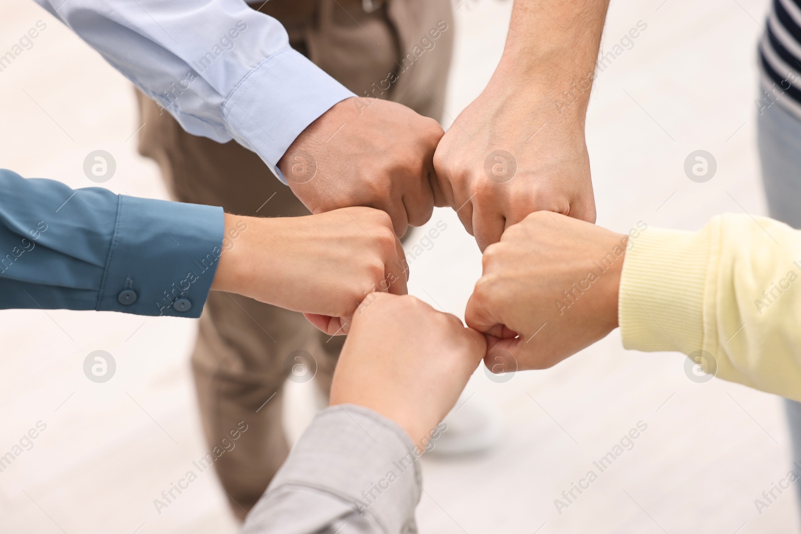 Photo of Teamwork. Group of employees joining hands in office, closeup