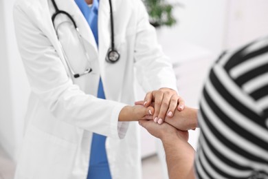 Healthcare worker supporting patient in hospital, closeup