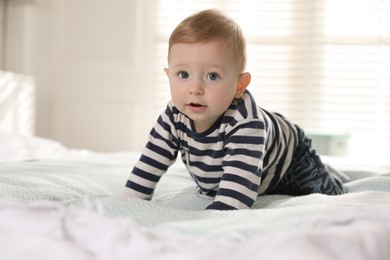 Cute little baby on bed at home, space for text