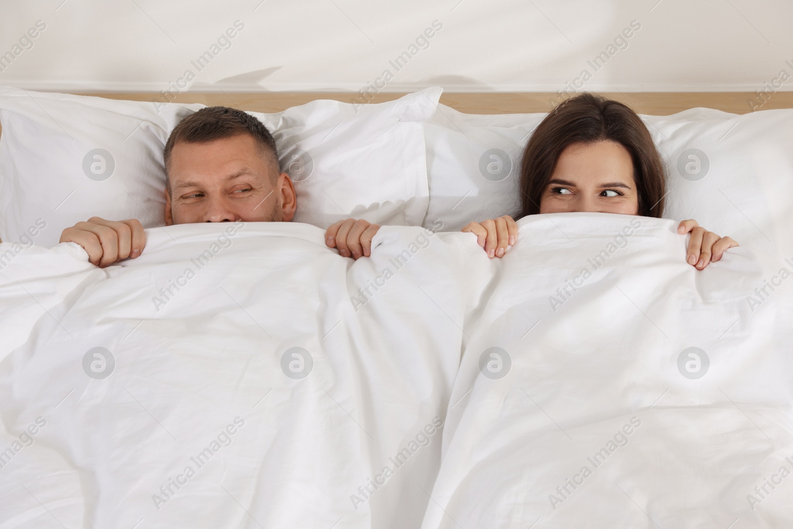 Photo of Lovely couple lying in bed at home