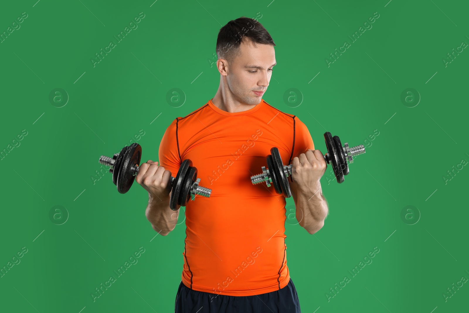 Photo of Man exercising with barbells on green background