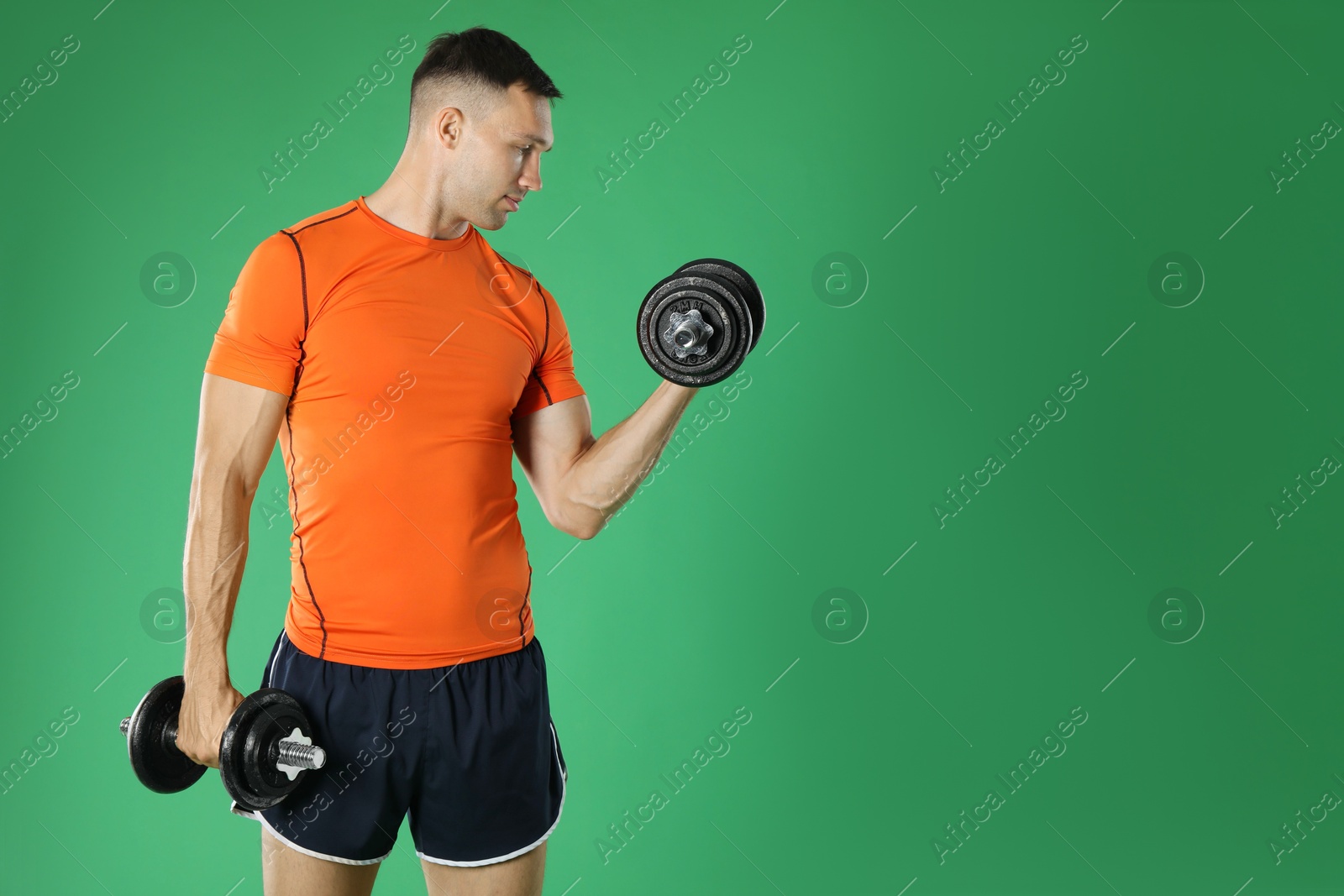 Photo of Man exercising with barbells on green background, space for text