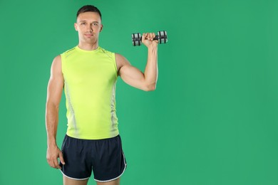 Photo of Man exercising with dumbbell on green background, space for text