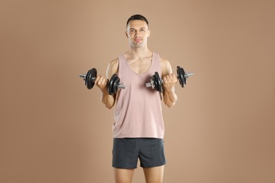 Photo of Man exercising with barbells on light brown background