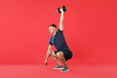 Photo of Man exercising with barbell on red background