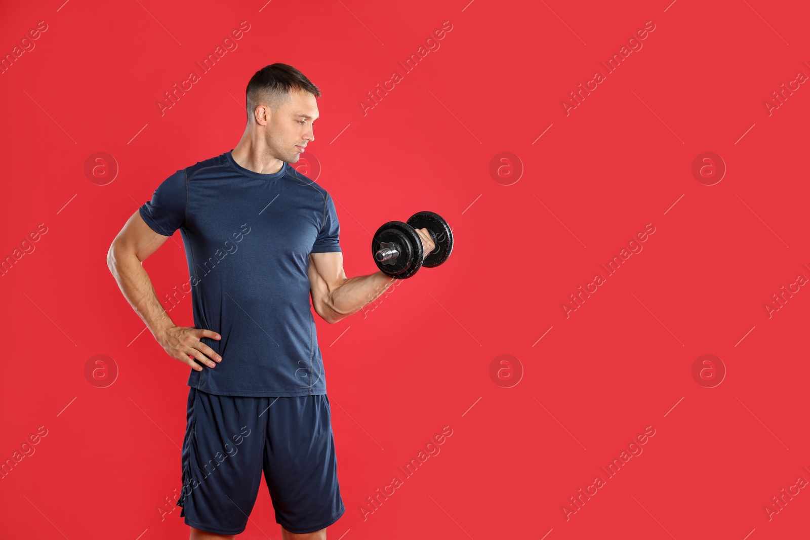 Photo of Man exercising with barbell on red background, space for text