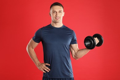 Man exercising with barbell on red background