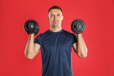 Photo of Man exercising with barbells on red background