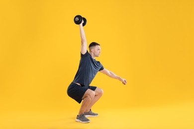 Photo of Man exercising with barbell on yellow background