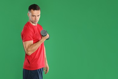 Photo of Man exercising with dumbbell on green background, space for text