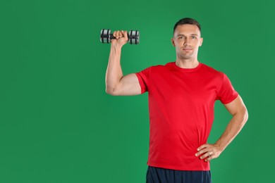 Photo of Man exercising with dumbbell on green background, space for text