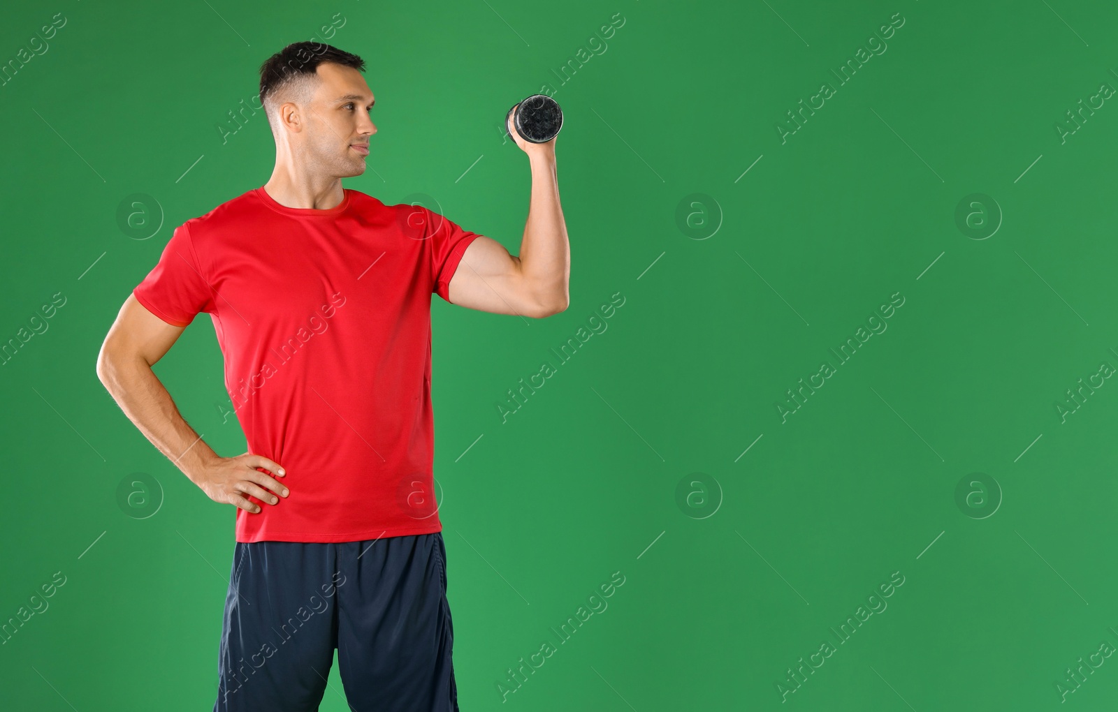 Photo of Man exercising with dumbbell on green background, space for text