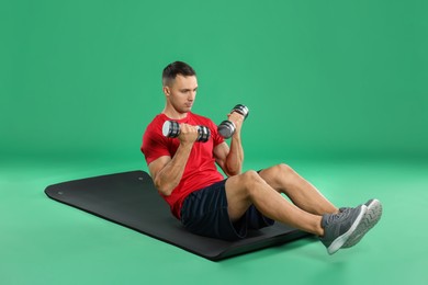 Photo of Man exercising with dumbbells on green background