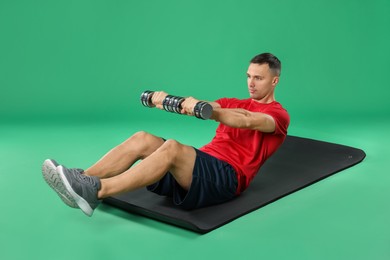 Photo of Man exercising with dumbbells on green background