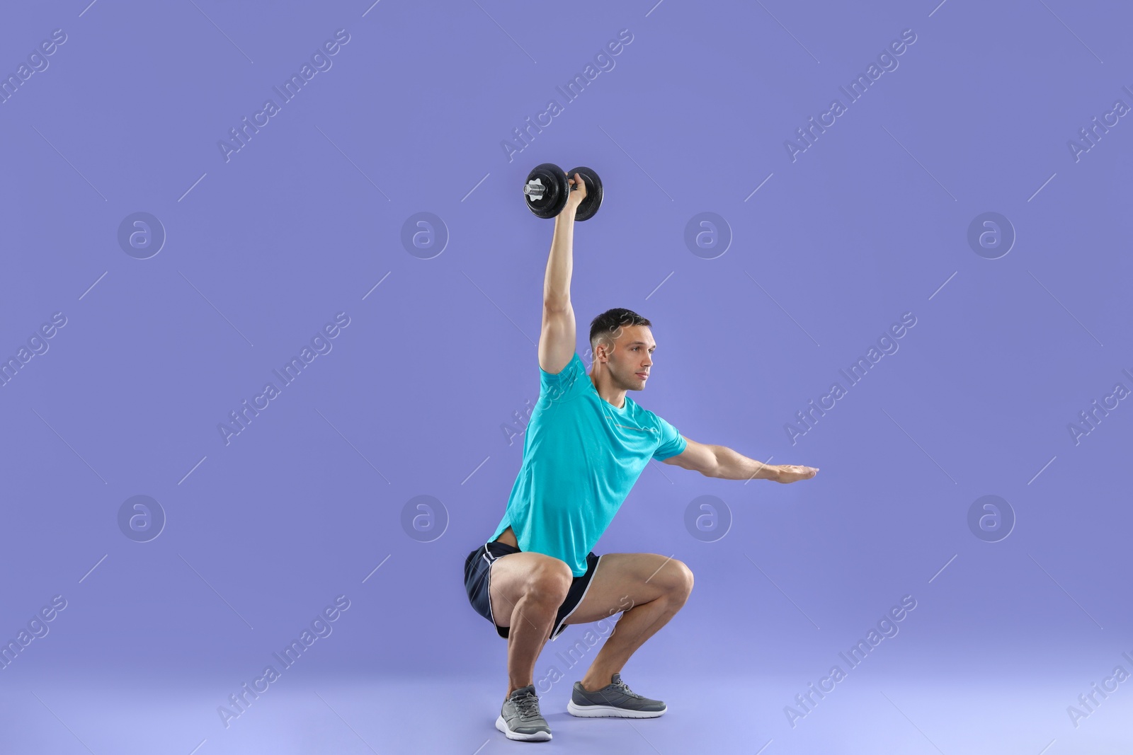 Photo of Man exercising with barbell on violet background