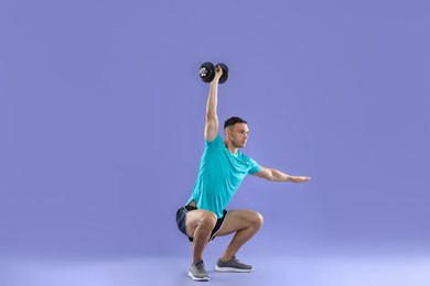 Photo of Man exercising with barbell on violet background