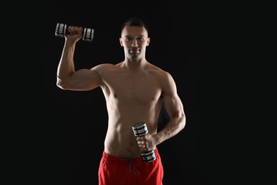 Photo of Man exercising with dumbbells on black background