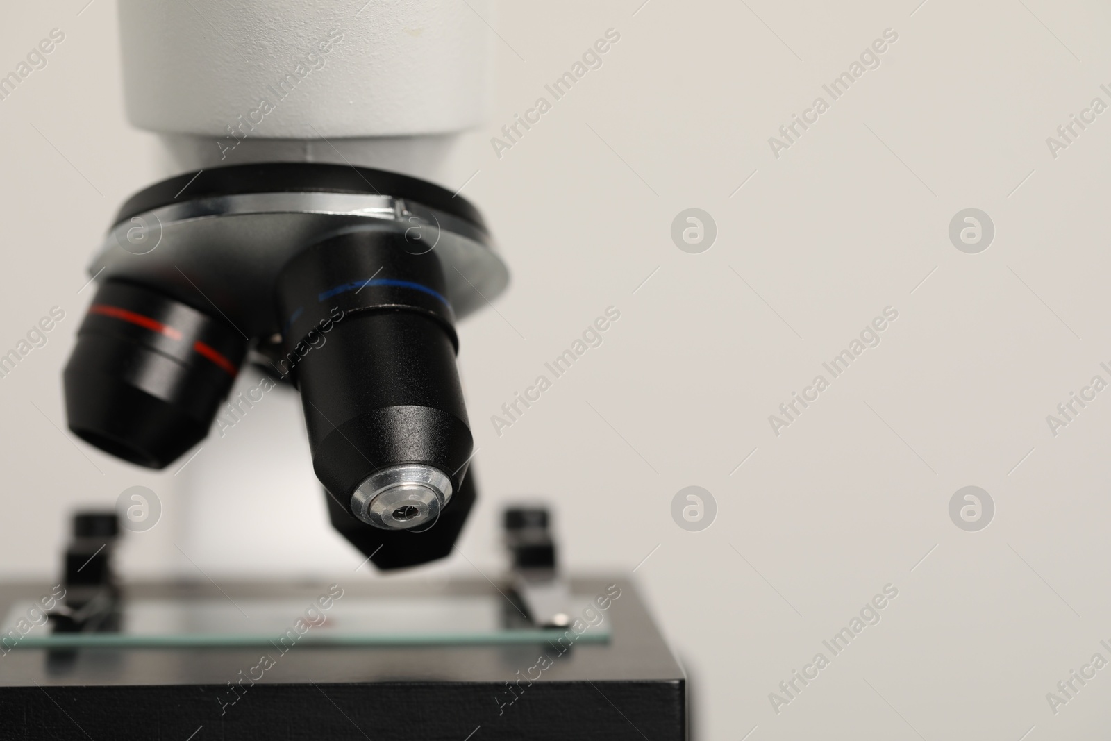 Photo of Science. Microscope with glass slide on light grey background, closeup. Space for text