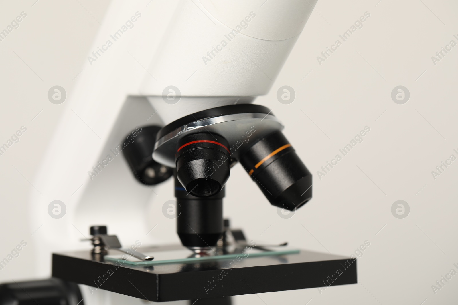 Photo of Science. Microscope with glass slide on light grey background, closeup