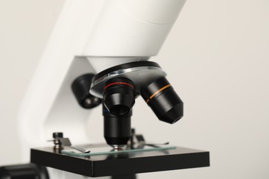 Photo of Science. Microscope with glass slide on light grey background, closeup