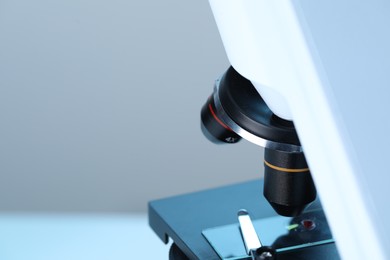 Science. Microscope with glass slide on blurred background, closeup. Space for text