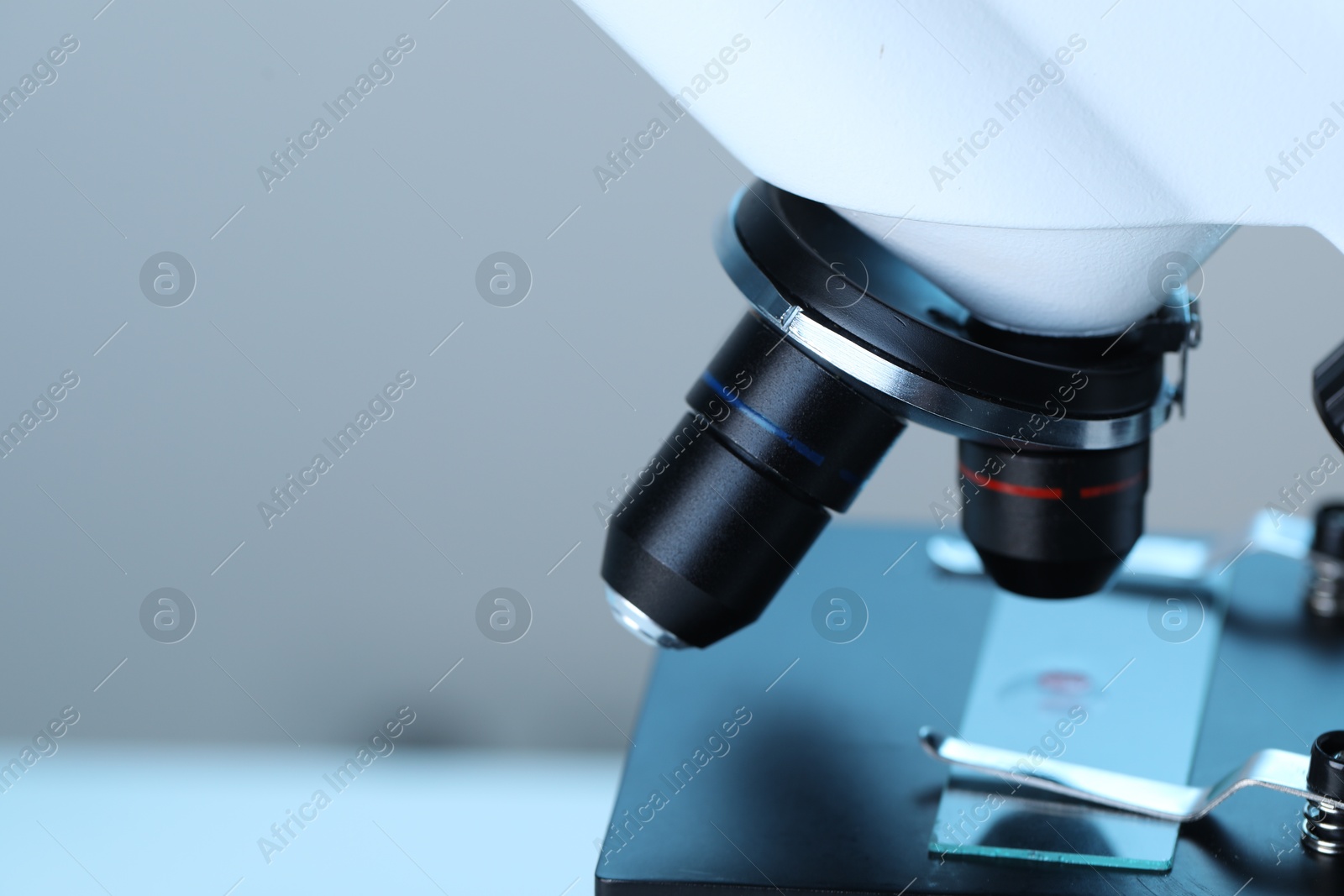 Photo of Science. Microscope with glass slide on blurred background, closeup. Space for text