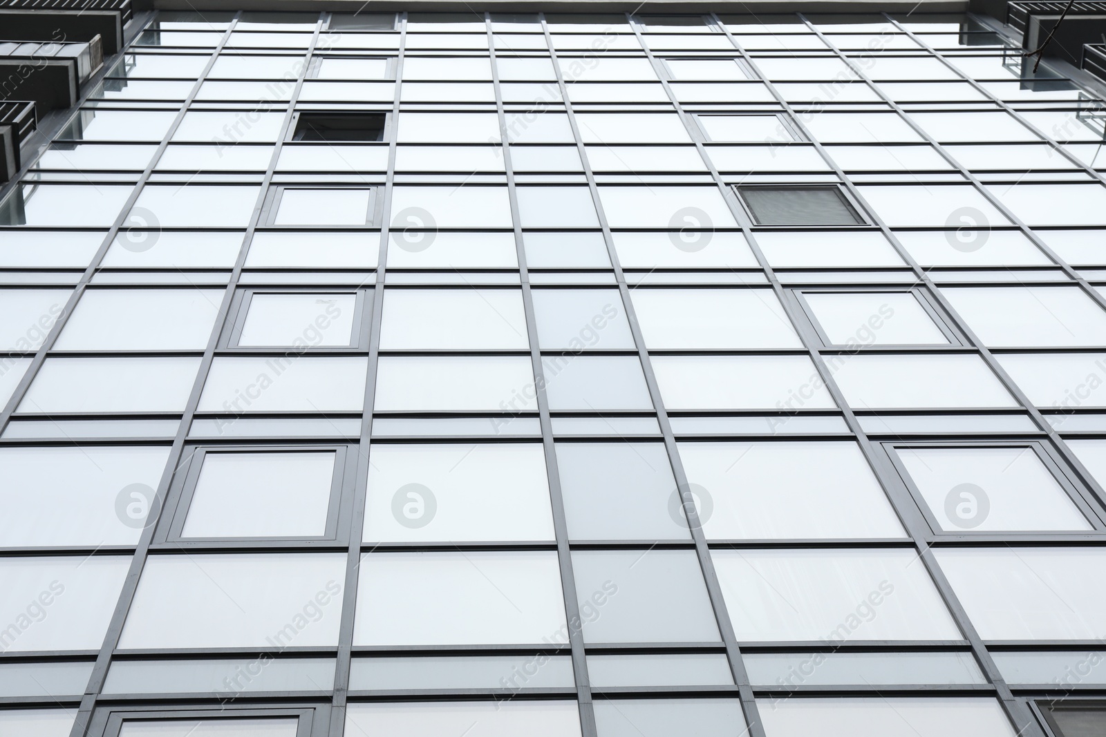 Photo of Modern building with many windows outdoors, low angle view