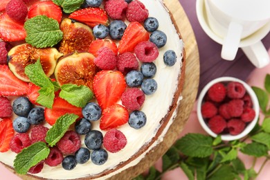 Delicious chocolate sponge cake with berries served on table, top view