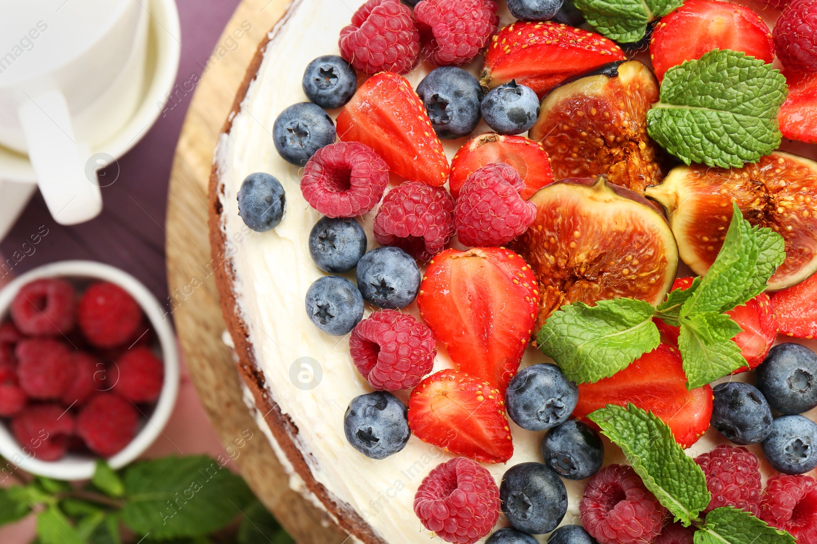 Photo of Delicious chocolate sponge cake with berries served on table, top view