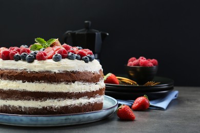 Photo of Delicious chocolate sponge cake with berries served on grey table, closeup