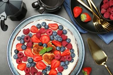 Photo of Delicious chocolate sponge cake with berries served on grey table, top view