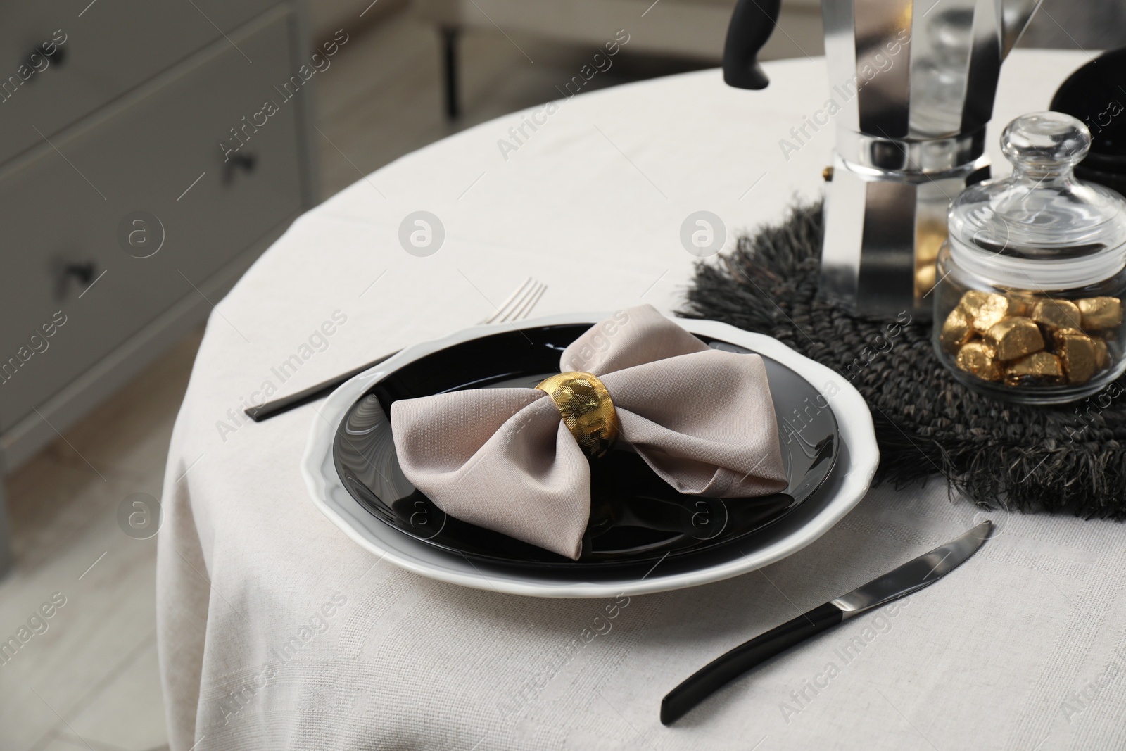 Photo of Stylish table setting with black dishware in dining room