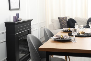 Photo of Stylish table setting with black dishware in dining room