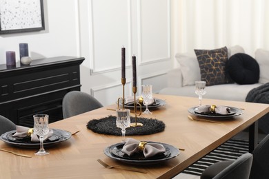 Photo of Stylish table setting with black dishware in dining room