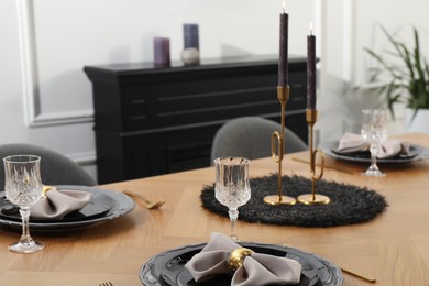 Photo of Stylish table setting with black dishware in dining room