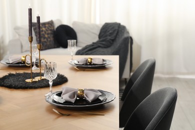 Photo of Stylish table setting with black dishware in dining room