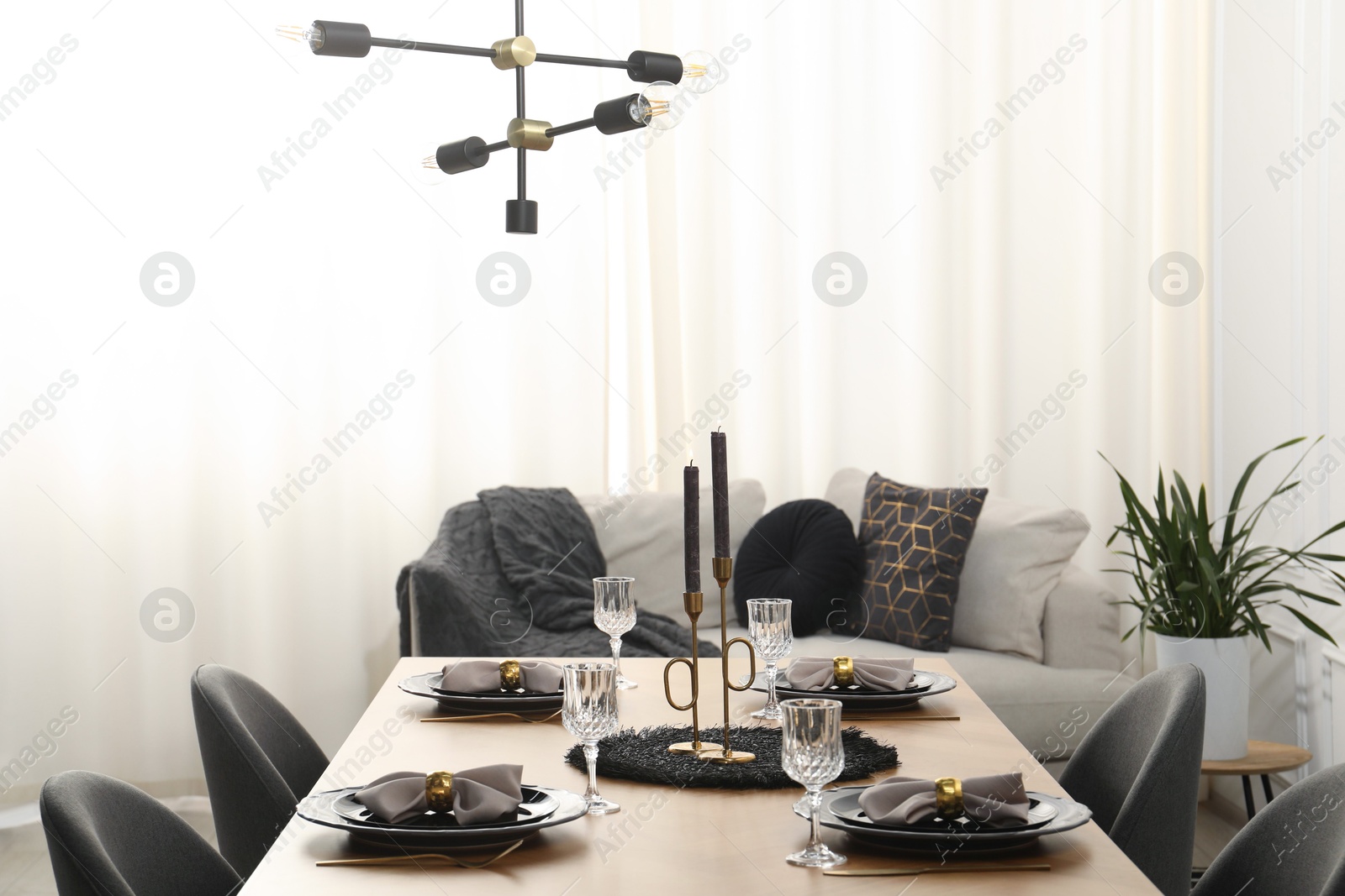 Photo of Stylish table setting with black dishware in dining room