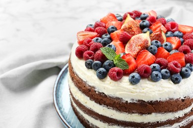 Photo of Delicious chocolate sponge cake with berries on white table, closeup