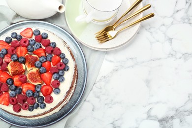 Photo of Delicious chocolate sponge cake with berries served on white marble table, flat lay. Space for text