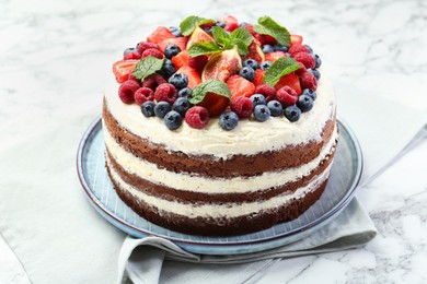 Photo of Delicious chocolate sponge cake with berries on white table, closeup