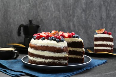 Photo of Delicious chocolate sponge cake with berries served on black table