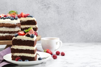 Photo of Piece of delicious chocolate sponge cake with berries served on white table. Space for text