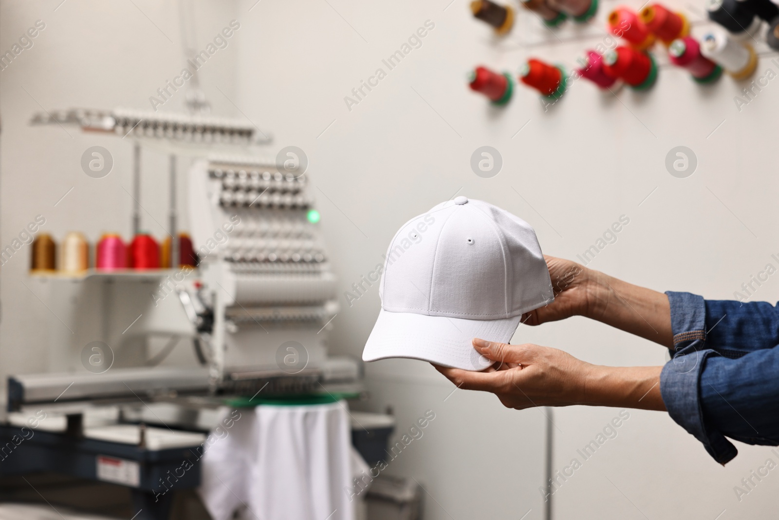 Photo of Woman with blank baseball cap for print indoors, closeup