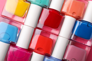 Photo of Set of different nail polishes as background, top view