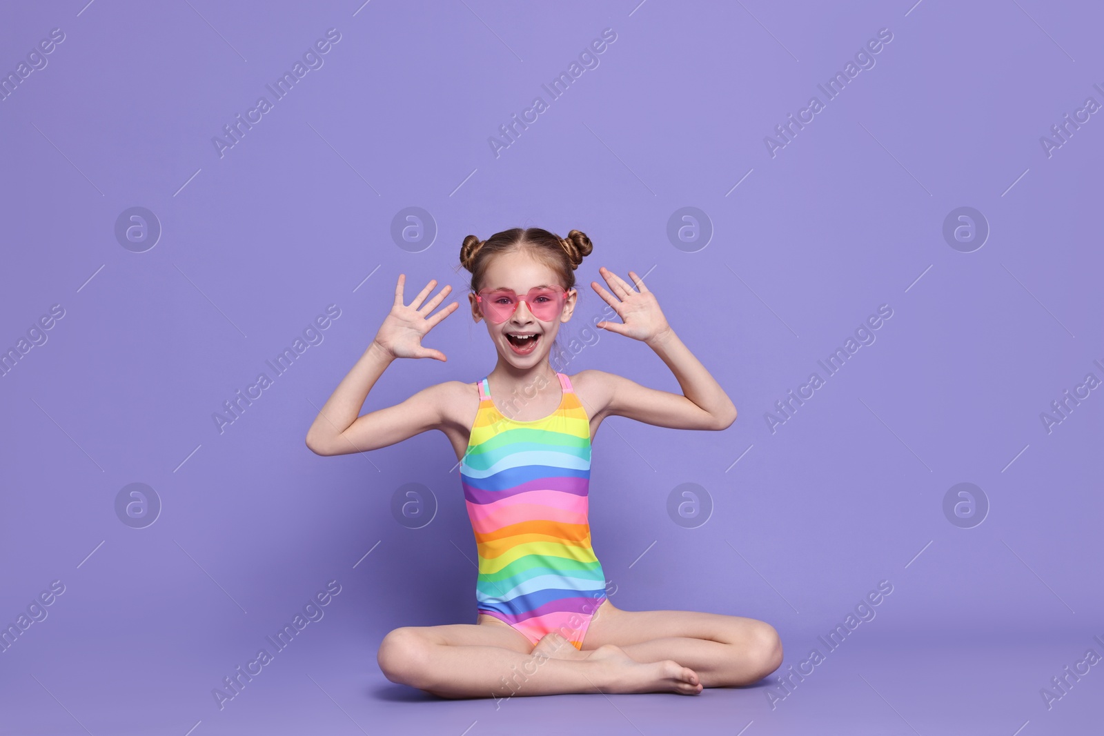 Photo of Happy girl in beachwear on purple background